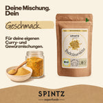 SPINTZ Bio-Bockshornklee für eigene Curry- und Gewürzmischungen, neben Gewürzglas und Holzlöffel.