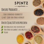 SPINTZ Superfoods Qualitätsversprechen mit naturbelassenen, unverfälschten Zutaten, von Hand ausgewählt und vegan, dargestellt mit verschiedenen Gewürzen und Beeren in Holzlöffeln