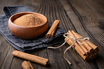 Aromatische Zimtstangen und fein gemahlenes Bio Zimtpulver in einer Holzschale – Grundlage der hochwertigen SPINTZ Bio Zimt Kapseln